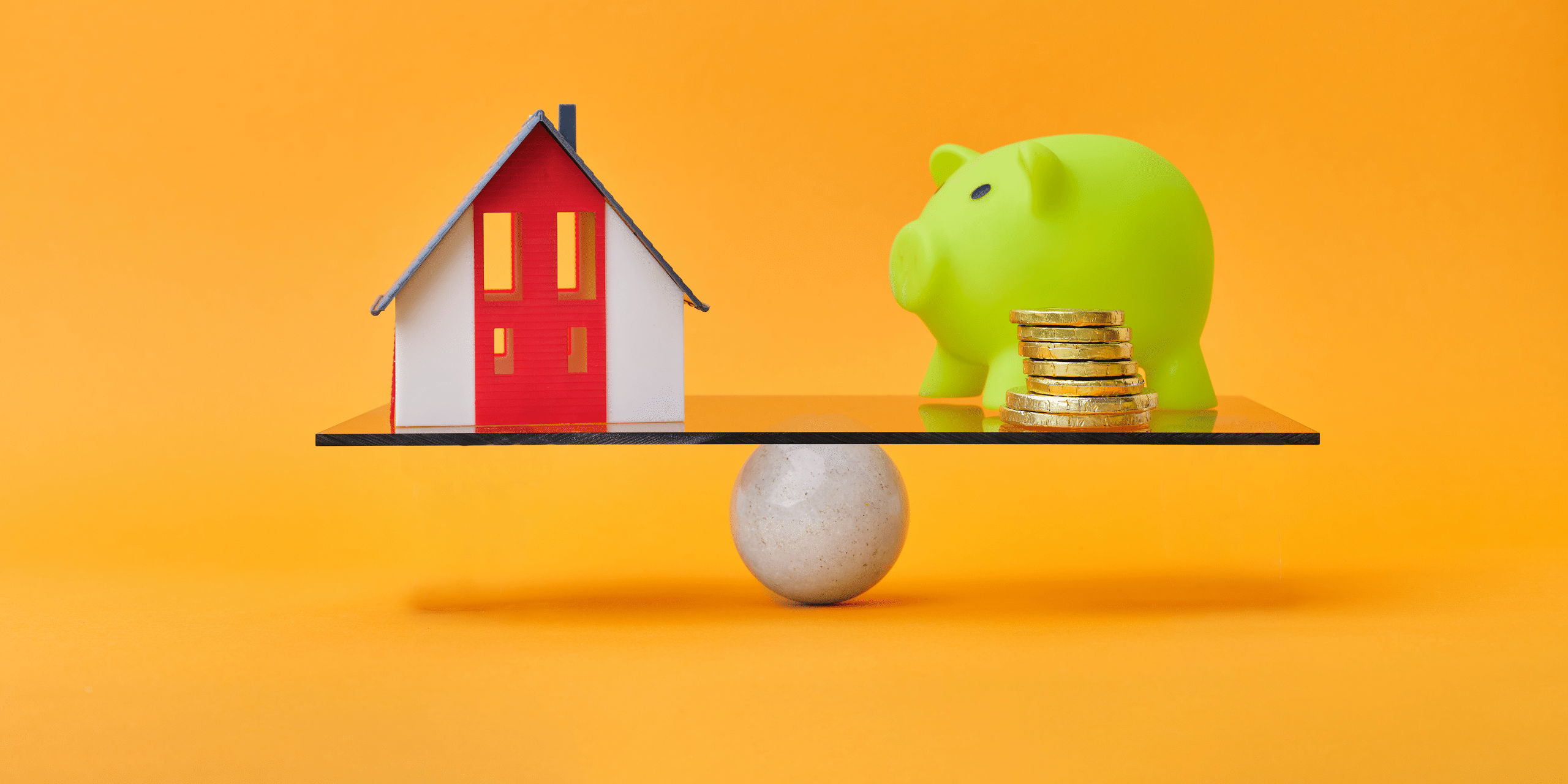 LJHHL_Blog_Offset_vs_Redraw Scale balances a small house model against a green piggy bank with coins on the other side, against an orange backdrop; conveys housing versus savings.